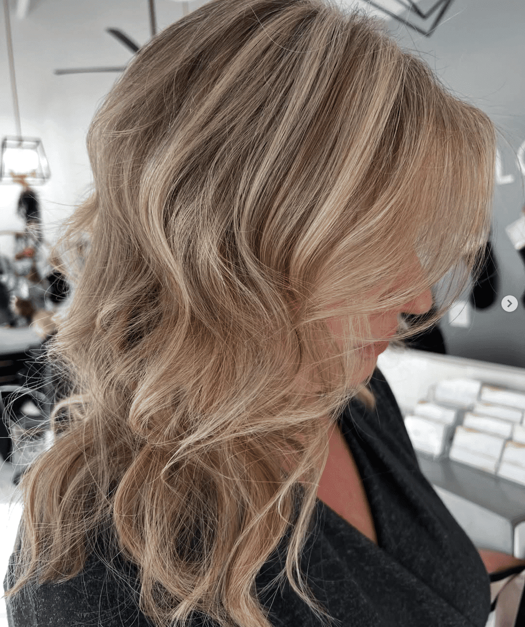 Blonde woman with wavy hair in a stylish salon setting.