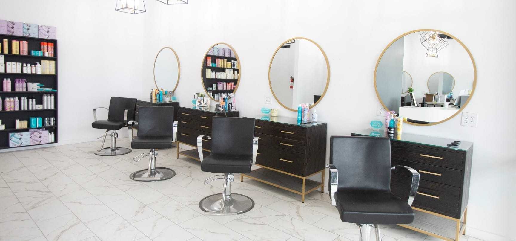 Modern hair salon with stylish chairs and mirrors, featuring shelves of beauty products.